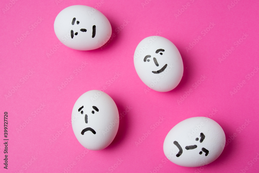 Eggs with different faces on a pink background with copy space. The concept of relations in society. Eggs with different faces on a pink background with copy space. The concept of relations in society.