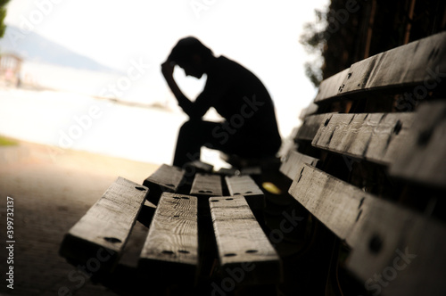 dramatic concept, Silhouette of Sad Depressed man sitting photo