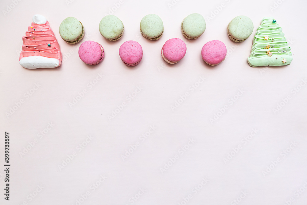 Macarons pink and green, meringues and candies on a light pink table. Sweets background. Festive concept Macarons pink and green, meringues and candies on a light pink table. Sweets background. Festive concept