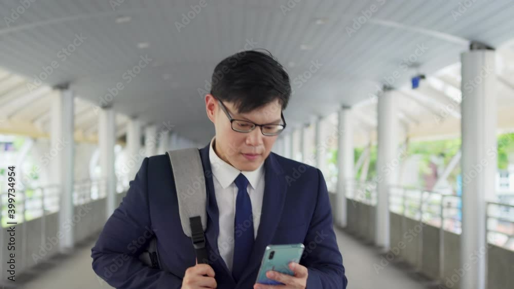 4K Confident Asian business man office worker in suit walking in city with texting online message on smartphone. Businessman using mobile phone for online working corporate business in office district 4K Confident Asian business man office worker in suit walking in city with texting online message on smartphone. Businessman using mobile phone for online working corporate business in office district