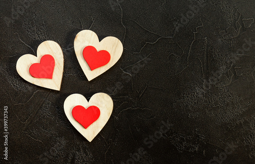 Valentine's day romantic concept. Red wooden hearts on black background.