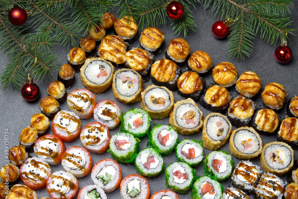Sushi on christmas background. Christmas tree with toys and sushi rolls set for menu and advertising. Christmas pattern with food Sushi on christmas background. Christmas tree with toys and sushi rolls set for menu and advertising. Christmas pattern with food