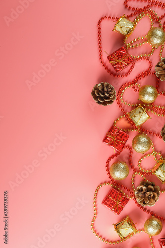 Fototapeta Naklejka Na Ścianę i Meble -  Christmas or new Year pink background with red and gold decorations for Christmas tree with free space.