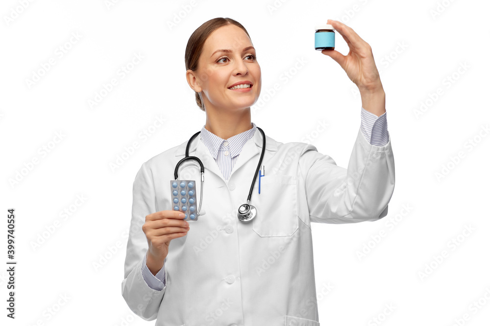 medicine, profession and healthcare concept - happy smiling female doctor with stethoscope comparing pills in jar and pack over white background medicine, profession and healthcare concept - happy smiling female doctor with stethoscope comparing pills in jar and pack over white background