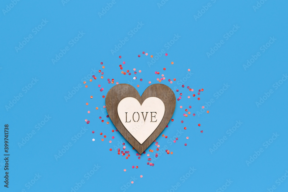 Saint valentine template. Wooden heart on blue background with colored confetti