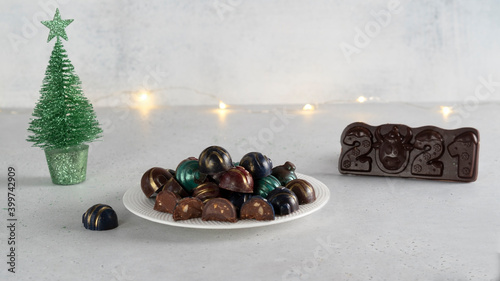 Canvas Print Chocolate candies with nuts in the shape of Christmas balls on a white plate