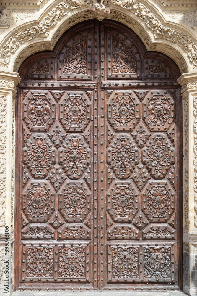 Detalle puerta con hojas de madera talladas y tachonadas en el arco central de la catedral de Astorga