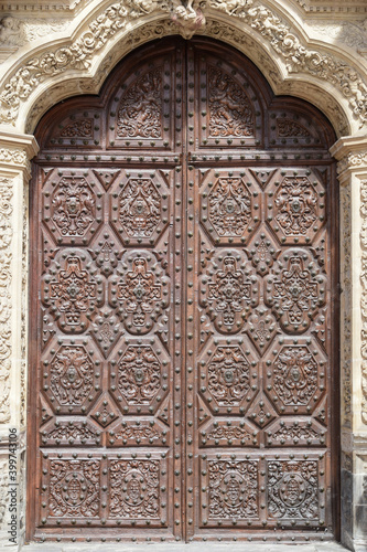 Detalle puerta con hojas de madera talladas y tachonadas en el arco central de la catedral de Astorga
