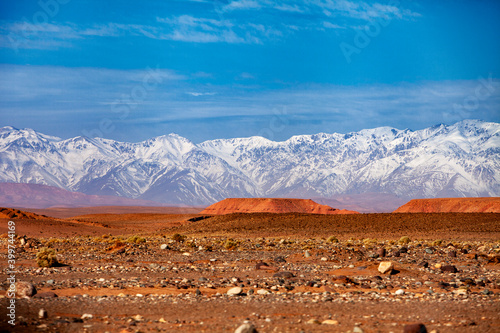 An impressive huge desert and some snowy mountains landscape in a sunny morning.