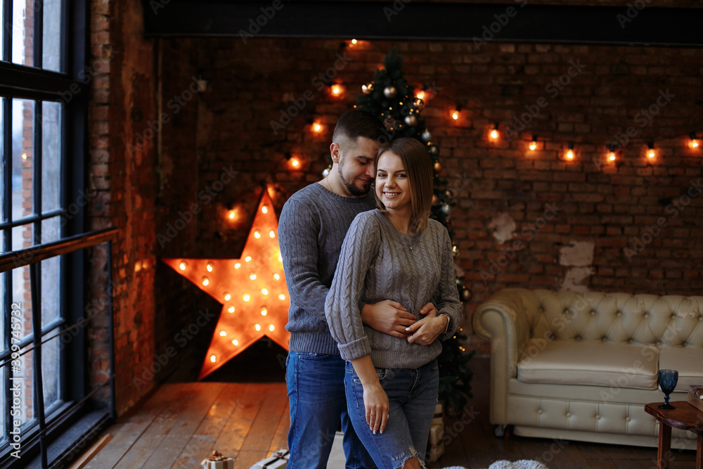 lovers in gray sweaters and jeans on the background of the Christmas tree lovers in gray sweaters and jeans on the background of the Christmas tree