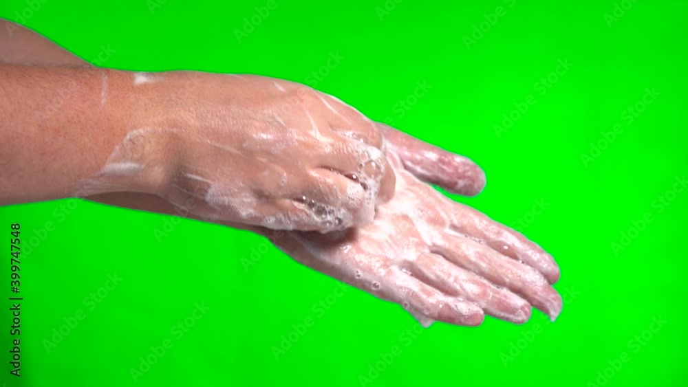 Soapy hands. Wash hands with soap. two hands wash each other with soap and foam. on a green background. Close-up. Soapy hands. Wash hands with soap. two hands wash each other with soap and foam. on a green background. Close-up.