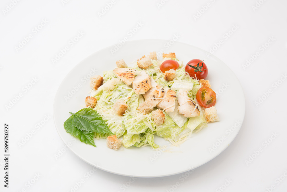Homemade Vegetable salad with chicken and cheese on white rectangular plate on a white background Homemade Vegetable salad with chicken and cheese on white rectangular plate on a white background