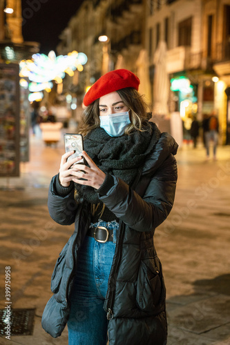 girl with phone and mask on street