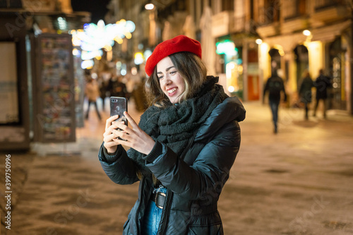 girl with phone on street at night