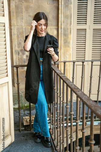 Girl watching a phone on balcony