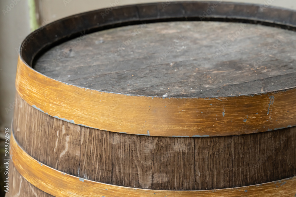 Fototapeta premium old and weathered oak barrel with copper hoop close-up