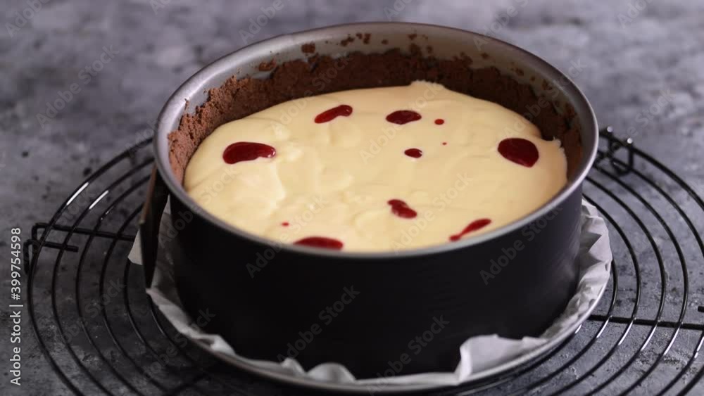 Woman preparing cheesecake with berry sauce in the kitchen. Woman preparing cheesecake with berry sauce in the kitchen.