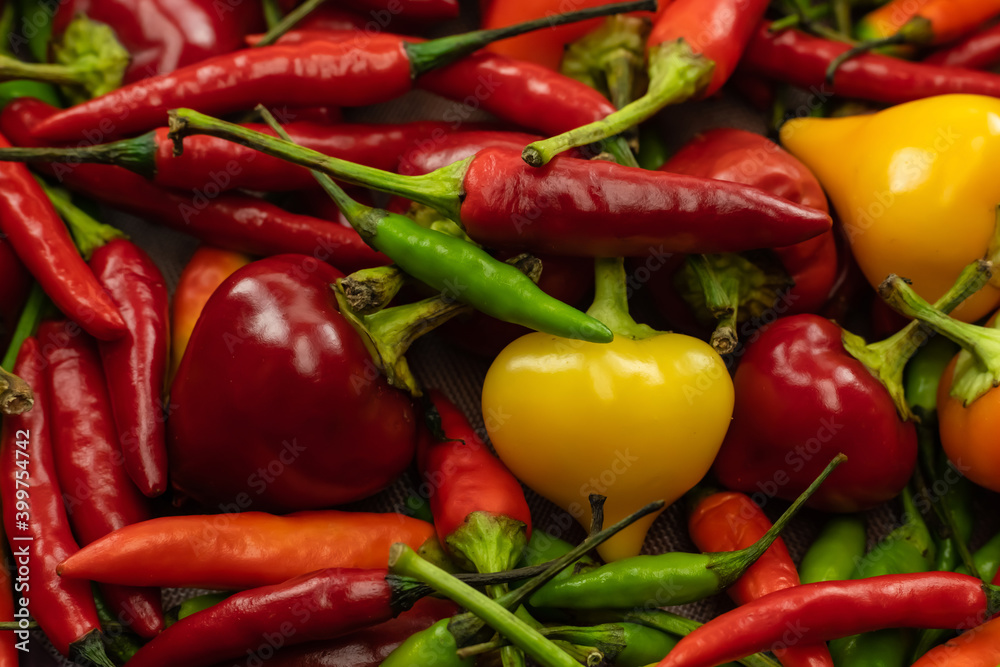 hot yellow pepper among red chili pods vegetable background