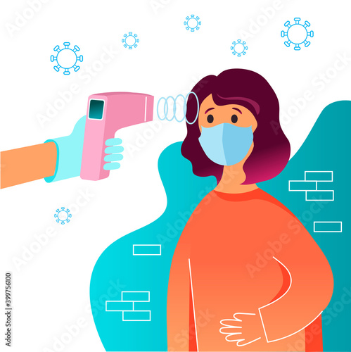 The medics arm measures the girl's temperature with an electronic thermometer. The girl is wearing a mask on her face. Control of body temperature during the coronavirus pandemic.