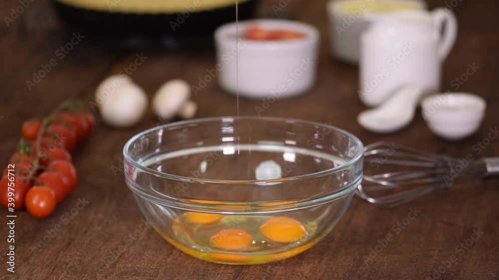 Whisking three fresh raw chicken eggs in a glass bowl. Whisking three fresh raw chicken eggs in a glass bowl.