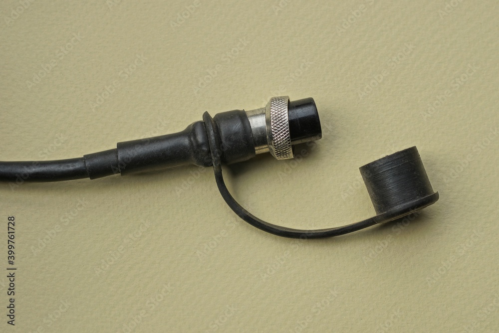 one black long cord with plug on a brown table one black long cord with plug on a brown table