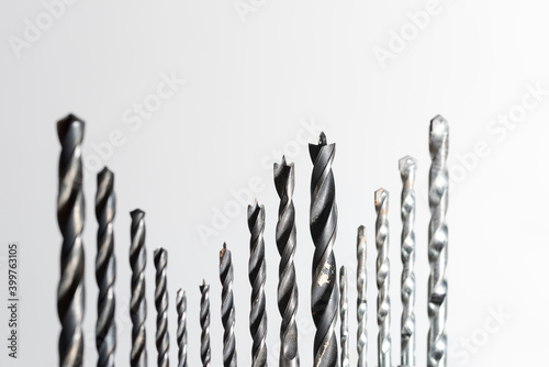 Detail of set of various drills in different sizes for wood, iron and concrete materials collocated together isolated on white background