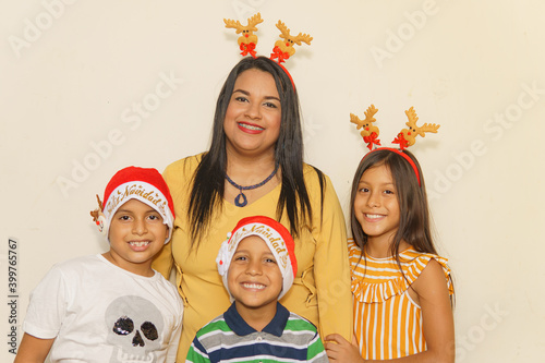 mom with her two sons and daughter with Christmas hats on a white background