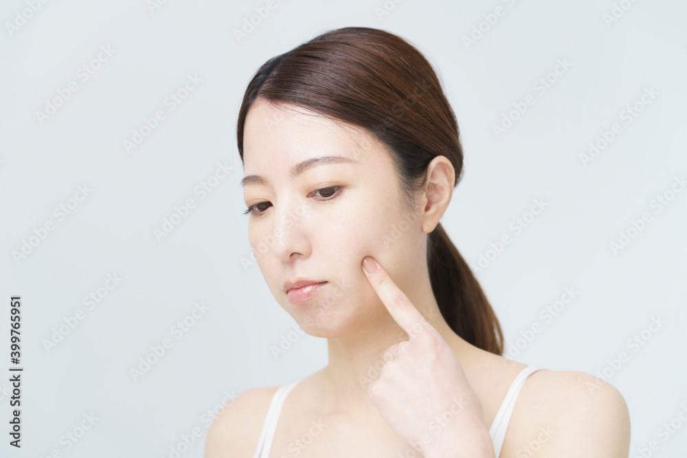 頬を触って肌の状態をチェックする女性