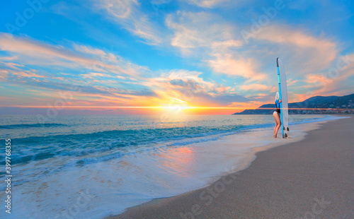 Fototapeta Naklejka Na Ścianę i Meble -  Beautiful surfer woman on the Cleopatra beach at sunset - Alanya, Turkey