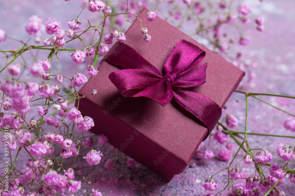 Gift box with burgundy color and gypsophile. Greeting card for Valentine's Day, anniversary, Mother's Day and birthday greetings, has a copy of the space Gift box with burgundy color and gypsophile. Greeting card for Valentine's Day, anniversary, Mother's Day and birthday greetings, has a copy of the space