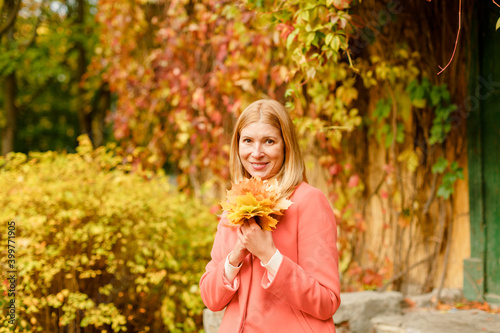 Woman in the autumn park. Girl on a background of fall. Autumn yellow and red leaves