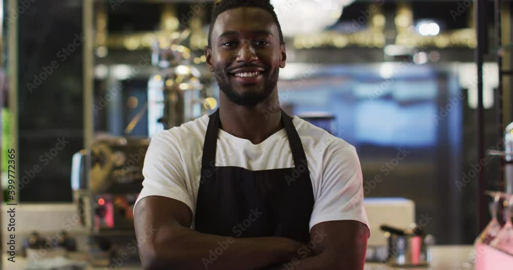 Portrait of african american barista smiling to camera wearing apron in cafe