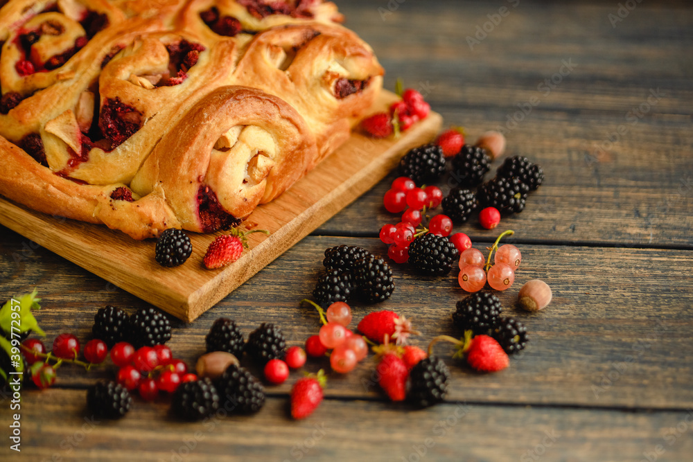 Berry yeast dough pie for tea. Sweet pastries with berry jam. Blackberries, strawberries and currants in dessert. Handmade cake