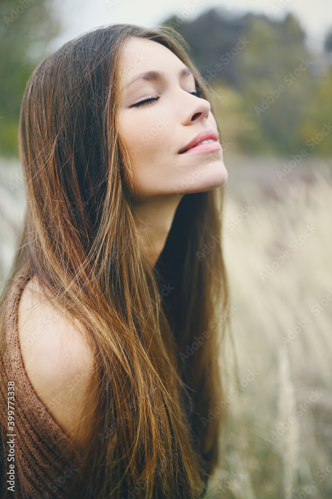 Fototapeta premium Closeup of a young cowboy woman in autumn dry grass. Western style.