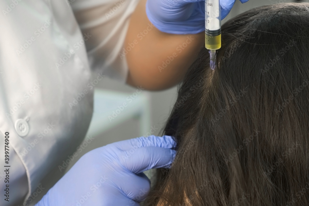 Doctor trichologist making injections mesotherapy with vitamins in
