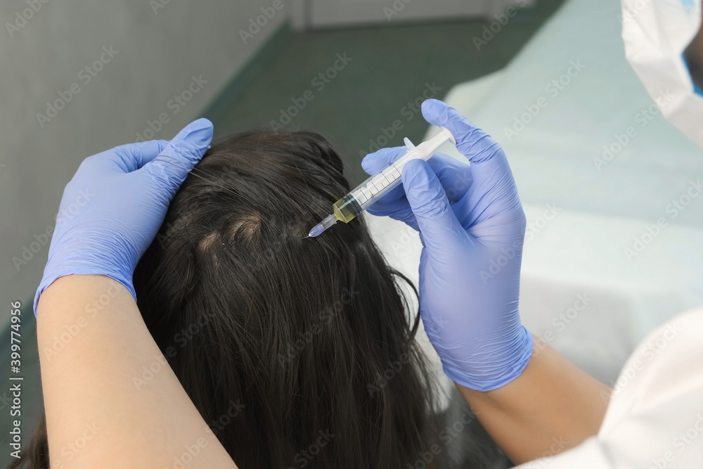 Naklejka premium Doctor trichologist making injections mesotherapy with vitamins in woman skin head for hair growth and against dandruff in cosmetology clinic, closeup view. Hairs cure. Trichology in medicine.