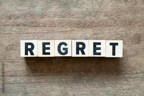 Alphabet letter block in word regret on wood background