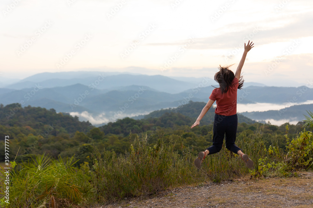 Happy Asian woman traveler jumping at view point for sun light. Travel Lifestyle adventure concept