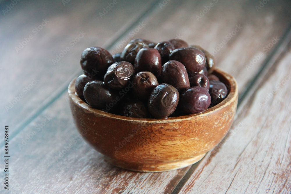fresh natural black olives in a wooden plate fresh natural black olives in a wooden plate
