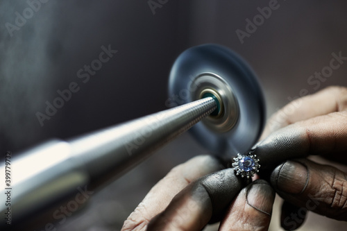 Closeup of jeweler hands polishing a ring.