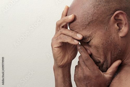 man praying to god with hands together Caribbean man praying with grey background stock image stock photo