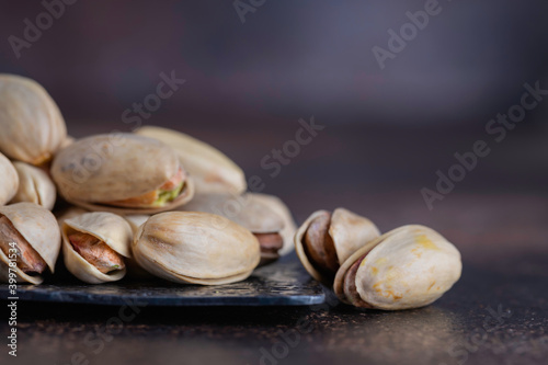 Slika na platnu Pistachios in steel bowl on dark background. Top view.
