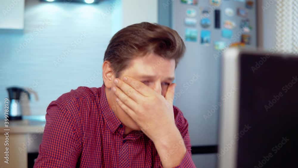 Man crying working at the computer