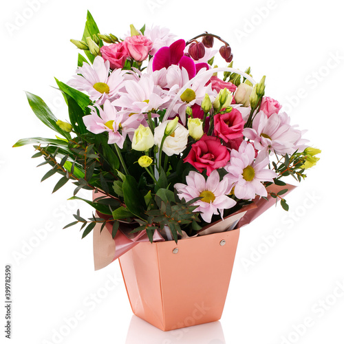Pink gerberas, roses, eustoma and green leaves in a pink box on a white background.
