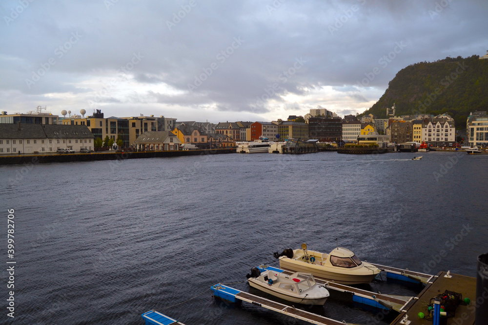 Seafront of Alesund, Norway. Art Nouveau architecture is historic heritage and landmark. Moored motor boats on the foreground. Seafront of Alesund, Norway. Art Nouveau architecture is historic heritage and landmark. Moored motor boats on the foreground.
