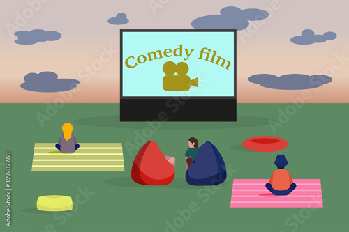 Open air cinema. People watching a movie in the clearing.