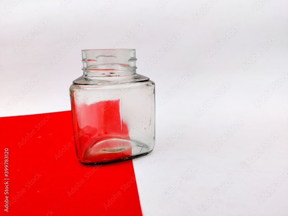 Empty glass jar on red sheet. Isolated on white background. Empty glass jar on red sheet. Isolated on white background.