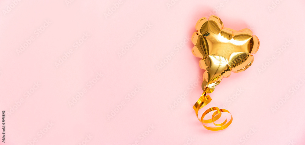 Gold balloon in the shape of a heart on a pink background. Valentine's day concept. Copy space for text. Gold balloon in the shape of a heart on a pink background. Valentine's day concept. Copy space for text.