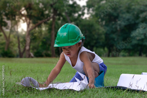 Bilde på lerret Dark skinned child boy pretending  construction engineer architect  looking blue