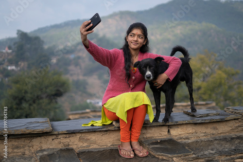 Young indian girl taking a selfie with her dog.